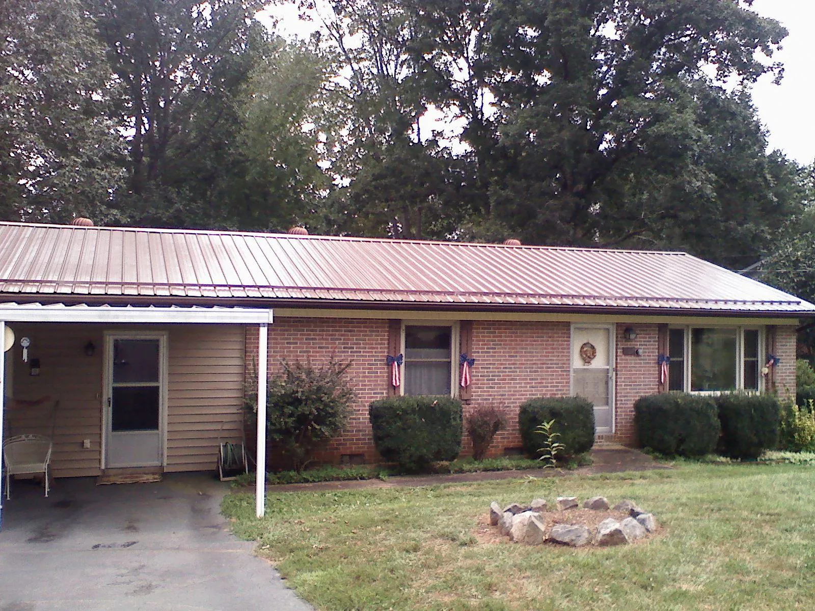 Bronze metal roof and carport on a brick ranch home — Roof Repair work by our crew in Pruden